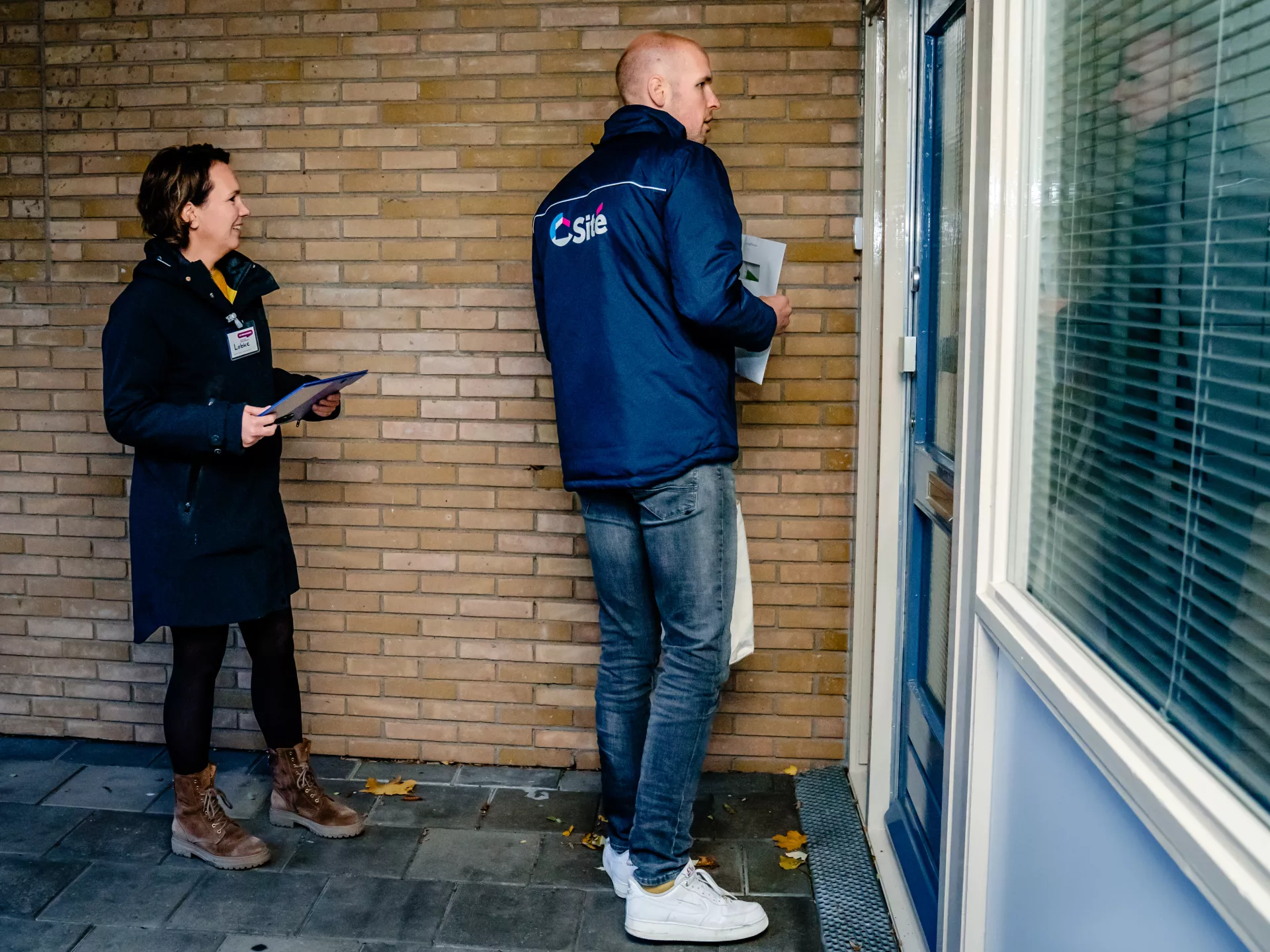 Twee mensen staan voor een dichte deur