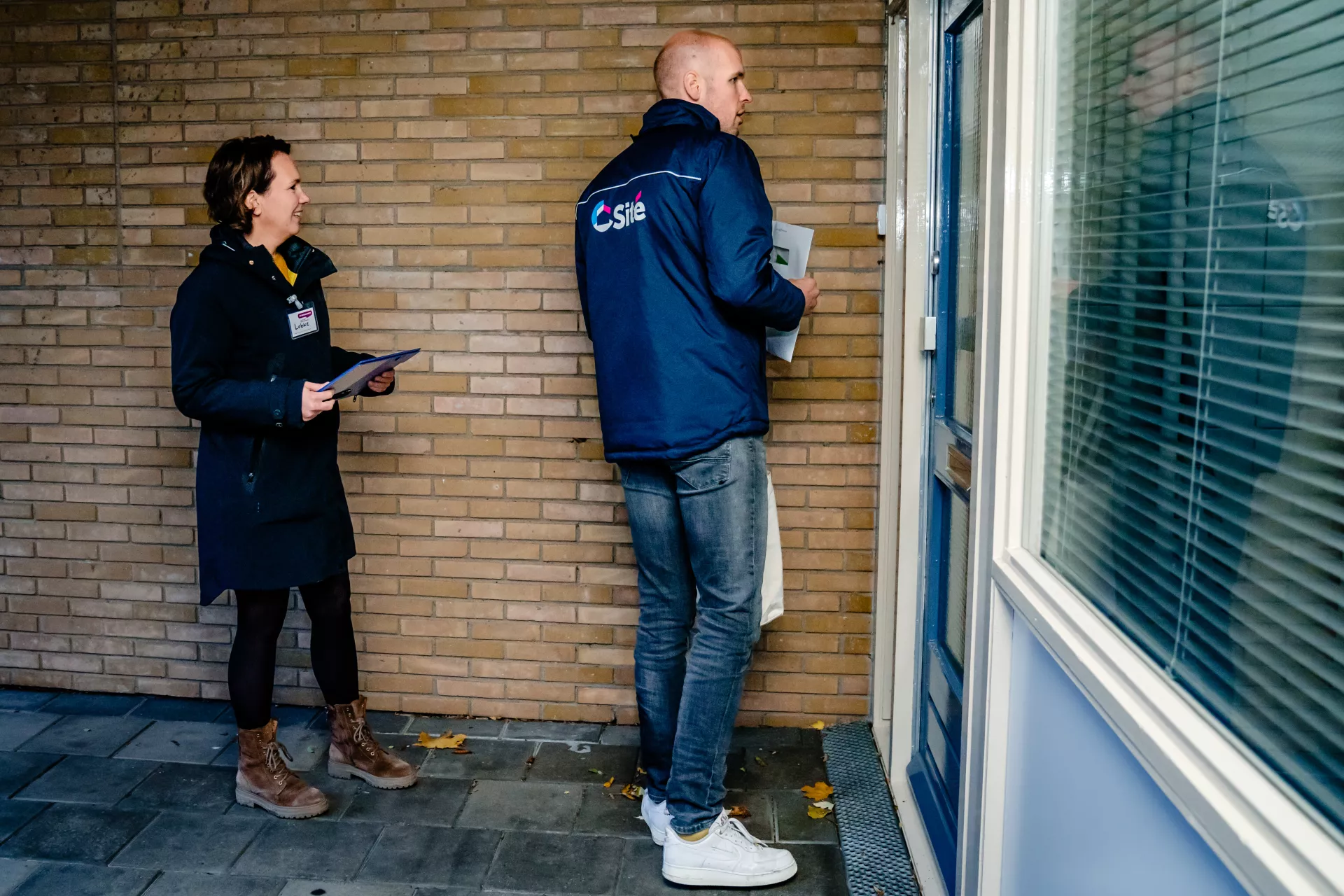 Twee mensen staan voor een dichte deur