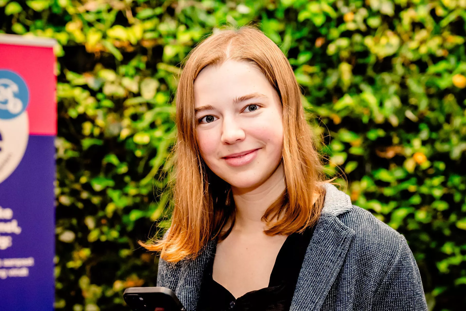 Dame met een mobiele telefoon in haar hand kijkt lachend